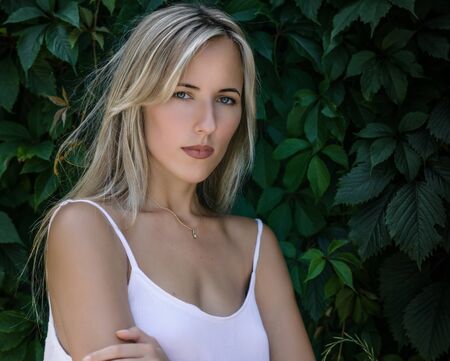 Outdoors portrait of beautiful young woman with green eyes.の写真素材