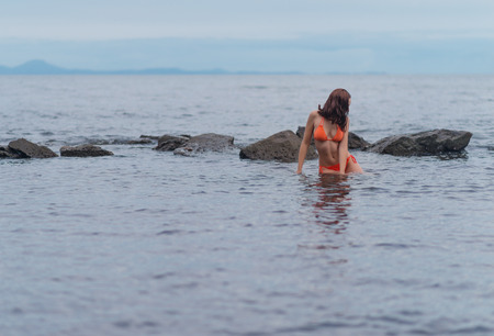 Beautiful woman in a orange bikini in the sea.の写真素材