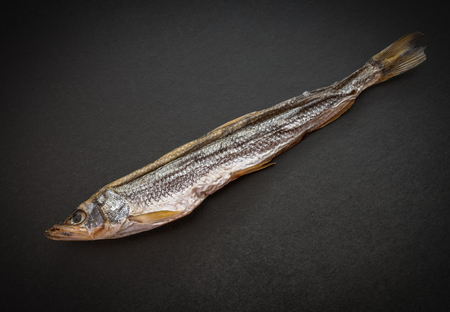 Dried smelt on a dark background. Selective focus.