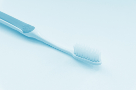 Toothbrush closeup on light blue background. Color toned.の写真素材