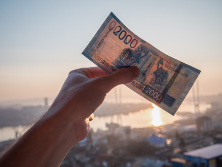 New russian 2000 rubles in hand over city background.の写真素材