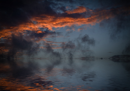 Dramatic sunset with clouds reflected in water.
