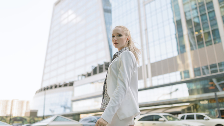 Outdoors portrait of young woman in white jacket.の写真素材