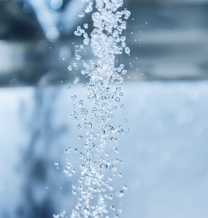 Water flowing down the hole in a kitchen sink. Selective focus.の写真素材