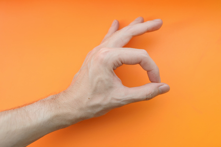 Hand sign ok on orange background.の写真素材