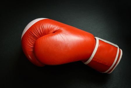 Old and used boxing glove on dark background.の写真素材