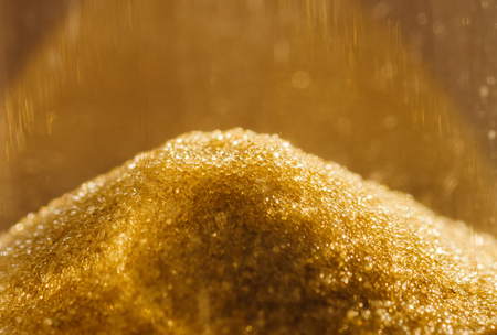 Sand grains in the hourglass. Shallow depth of field.の写真素材