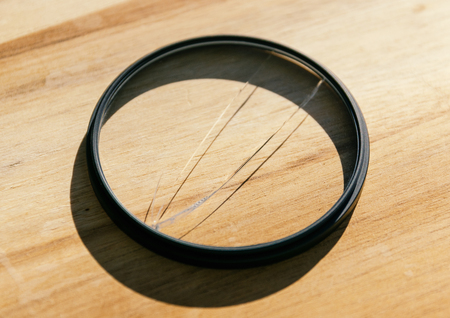 Broken photo-filter on wooden background.の写真素材