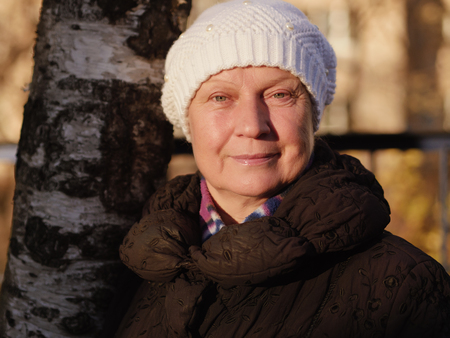 Portrait of a beautiful middle-aged woman outdoors. Selective focus. Color toned.の写真素材