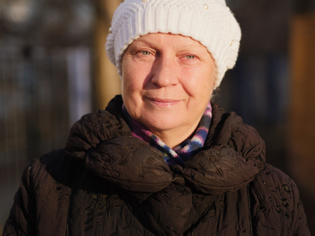 Portrait of a beautiful middle-aged woman outdoors. Selective focus. Color toned.の写真素材
