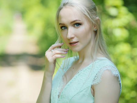 Summertime portrait of young woman in the park.の写真素材