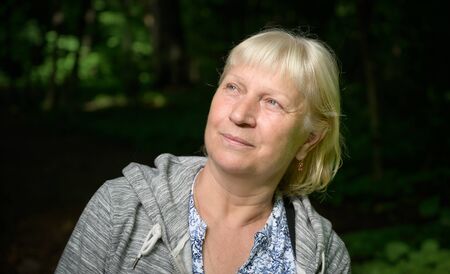 Portrait of a beautiful middle-aged woman in the park.の写真素材