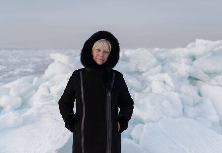 Winter portrait of a beautiful middle-aged woman in a fur coat.の写真素材