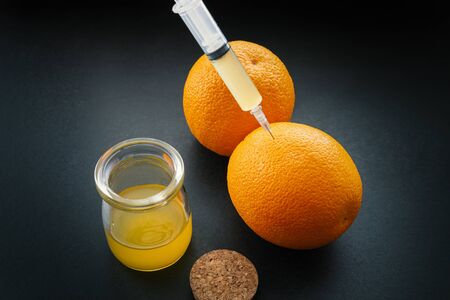 Orange with syringe injection colored liquid.の写真素材