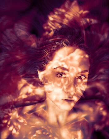 Double exposure of young woman and flowers.の写真素材