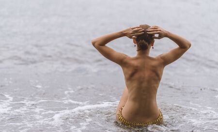 Beautiful woman on a beach in a foggy day.の写真素材