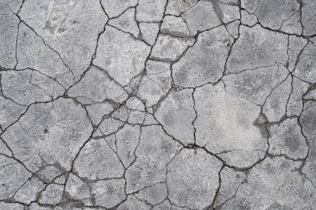 Terrain road with small rocks and cracks on the concrete wall.