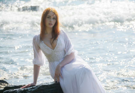 Young woman over blue sea background.の写真素材