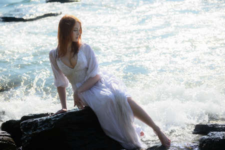 Young woman over blue sea background.の写真素材