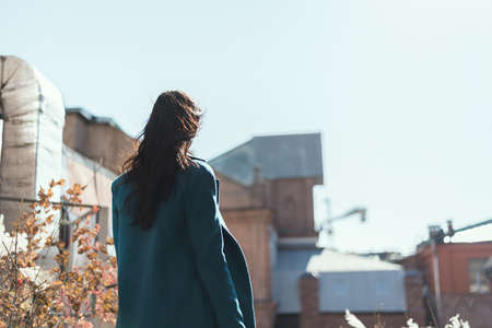 Portrait of a beautiful brunette girl in coat. View from back.の写真素材