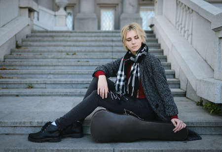 Beautiful girl in coat. With old case for violin in a hand.