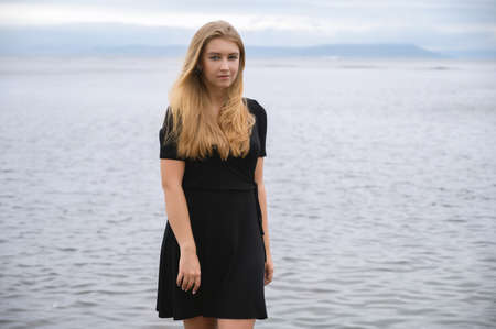 Woman in dress enjoys a walking near the sea shore.の写真素材