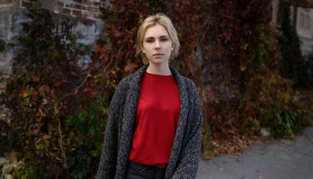 Young woman dressed in autumn coat and red sweater.の写真素材