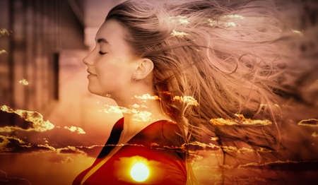 Double exposure of young woman and sunset sky.