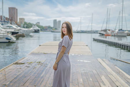 Woman in dress enjoys a walking near the sea shore.の写真素材