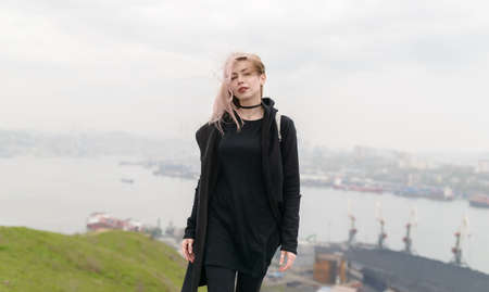 Young woman breathing fresh sea air with the ocean in the background.