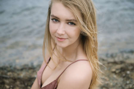 Young woman in pink dress on sand and enjoys sea.の写真素材