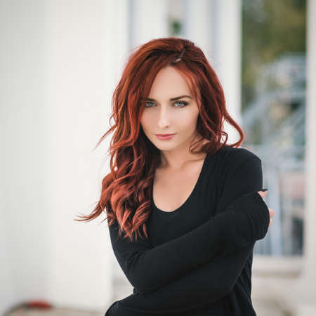 Portrait of attractive red haired young woman with blue eyes.の写真素材
