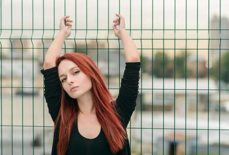 Portrait of attractive red haired young woman with blue eyes.