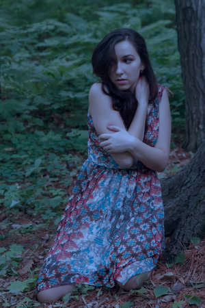 Scared young woman a forest at night.の写真素材