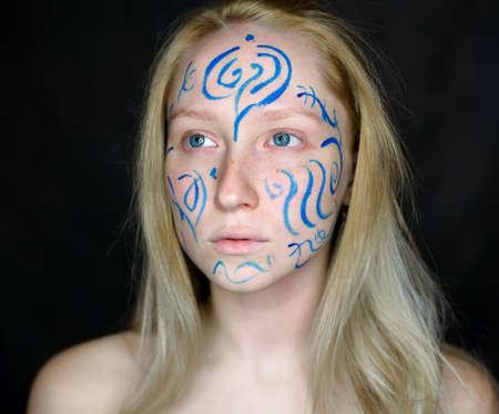 Portrait of young woman with paint on her face.の写真素材