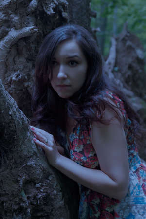 Scared young woman a forest at night.の写真素材