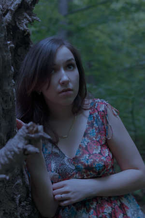 Scared young woman a forest at night.の写真素材
