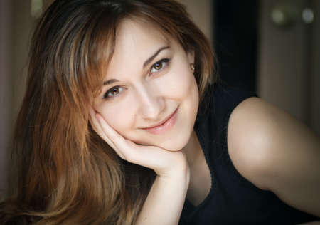 Closeup portrait of a beautiful young lady lying on the bed.の写真素材