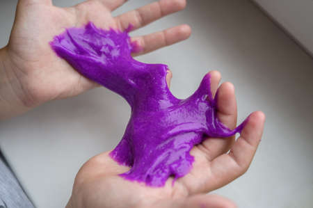 Little girl plays with toy called slime at home. Selective focus.の写真素材