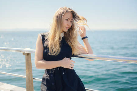 Woman in dress enjoys sea on the pier.の写真素材