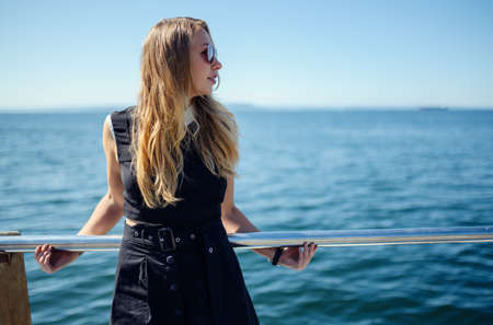 Woman in dress enjoys sea on the pier.の写真素材