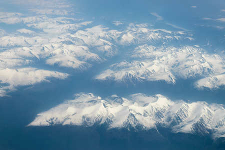 View from airplane on Earth surface - snow-capped mountains.の写真素材