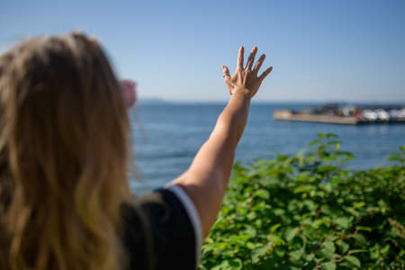 Summertime portrait of beautiful woman - she reaching to towards sky.の写真素材