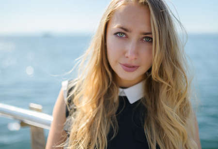 Woman in dress enjoys sea on the pier.の写真素材