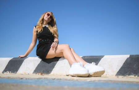 Woman in dress enjoys sea on the pier.の写真素材