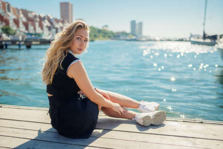 Woman in dress enjoys sea on the pier.の写真素材