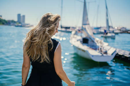 Woman in dress enjoys sea on the pier.の写真素材