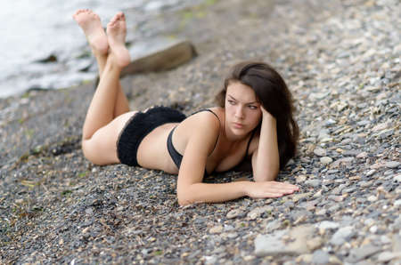Beautiful woman in black underwear on a beach. Selective focus.の写真素材