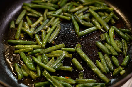 Fried beans in pods a pan. Seelctive focus.の写真素材