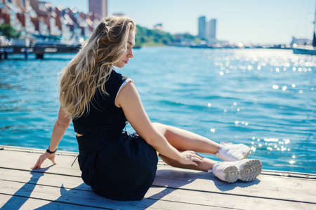 Woman in dress enjoys sea on the pier.の写真素材